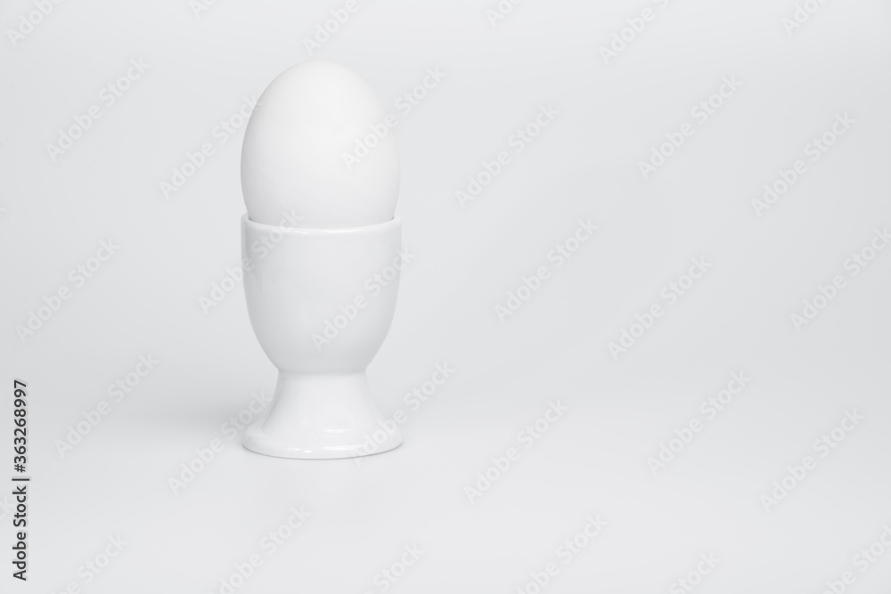 White duck egg in white egg cup - raised view White duck egg in white egg cup - raised view