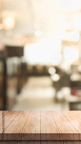 Empty wooden table top with lights bokeh on blur restaurant background