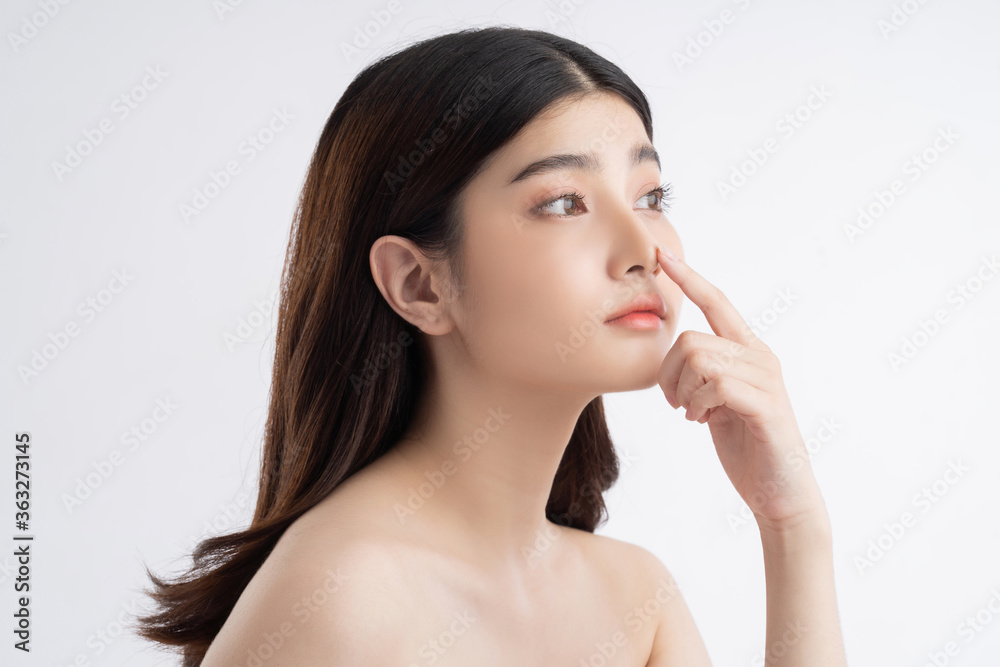 Beautiful asian woman with a beautiful face. She touches her nose Beautiful asian woman with a beautiful face. She touches her nose