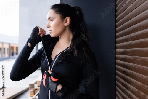 Bilde på lerret beautiful young sportswoman touching zipper on sports jacket