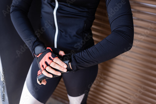 cropped view of woman standing and touching sport gloves