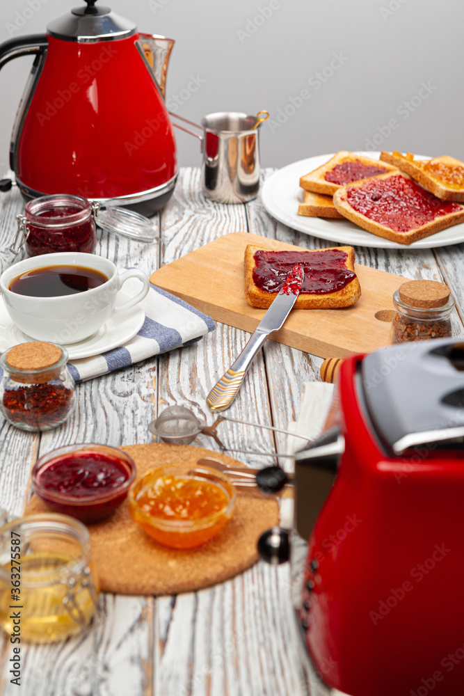 Photo of kitchen table with toasts, fruit jams and knife