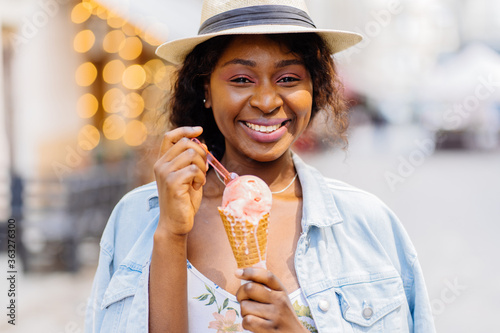 Portrait of a beautiful african woman eating one ice cream in the street.