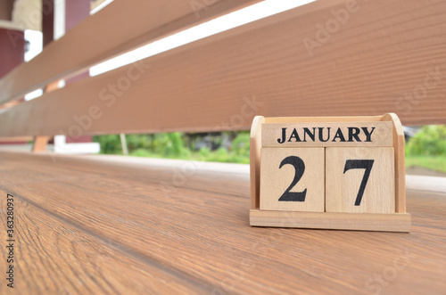 January 27, Number cube with wooden balcony background.