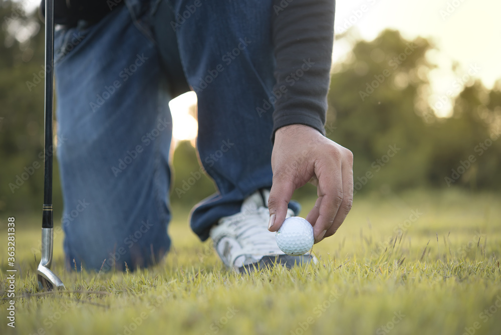 Hand of asian golfer holding golf on lawn,thailand people play golf