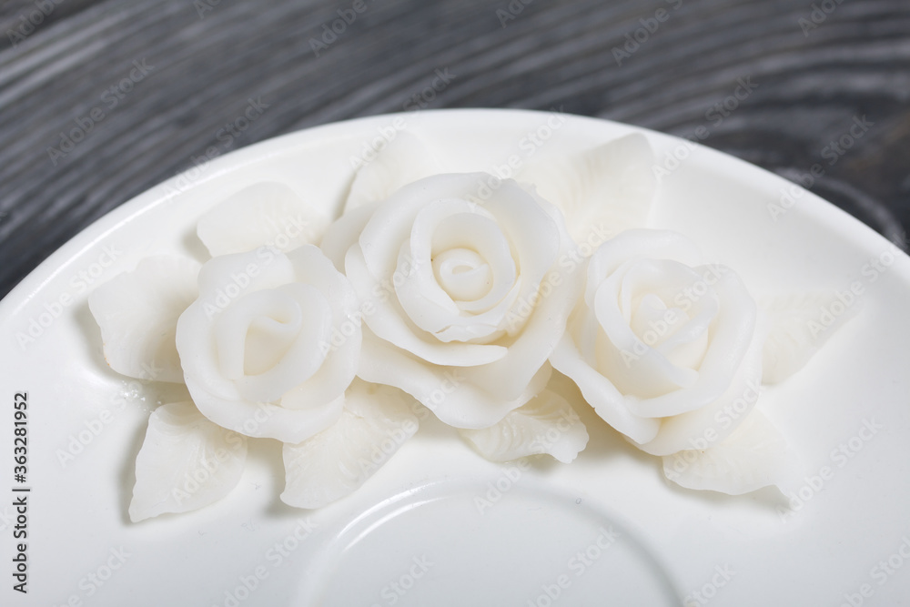 Handmade saucer decorated with polymer clay roses. Jewelry made of white polymer clay. Close up shot/ Handmade saucer decorated with polymer clay roses. Jewelry made of white polymer clay. Close up shot/