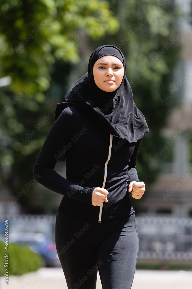 Young Arabian girl in hijab and sportswear jogging outside Stock Photo |  Adobe Stock