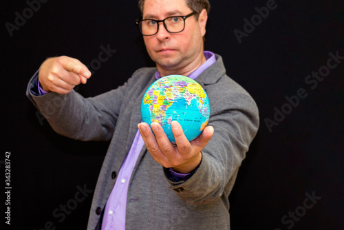 Close up of businessman holding digital globe in palm and shows at globe global business communications concept.