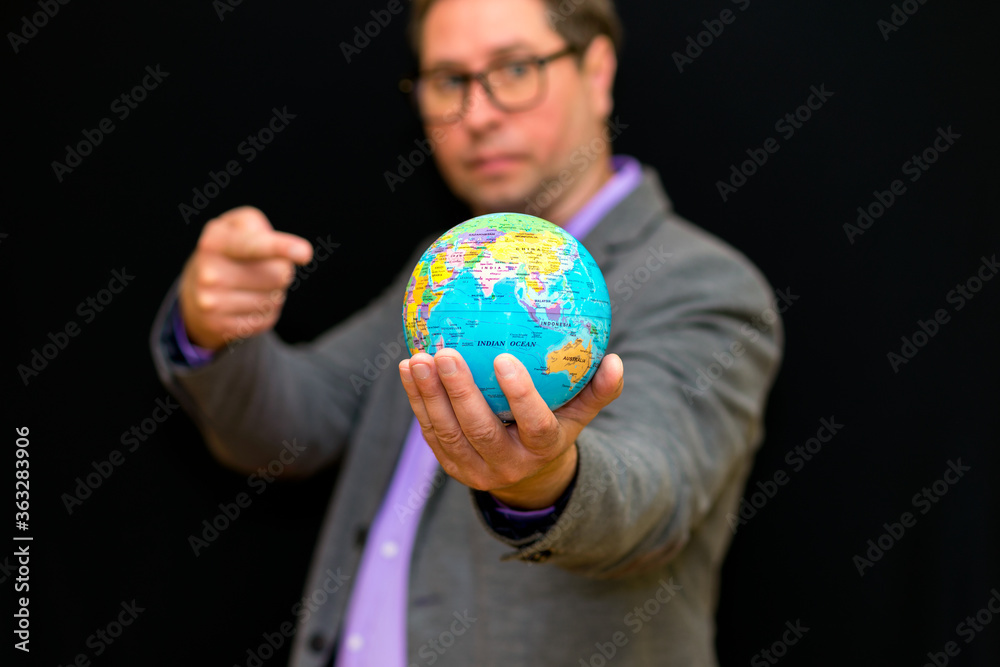 Close up of businessman holding digital globe in palm and shows at globe global business communications concept. Close up of businessman holding digital globe in palm and shows at globe global business communications concept.