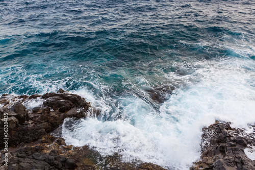 ocean waves hit and crash against stones
