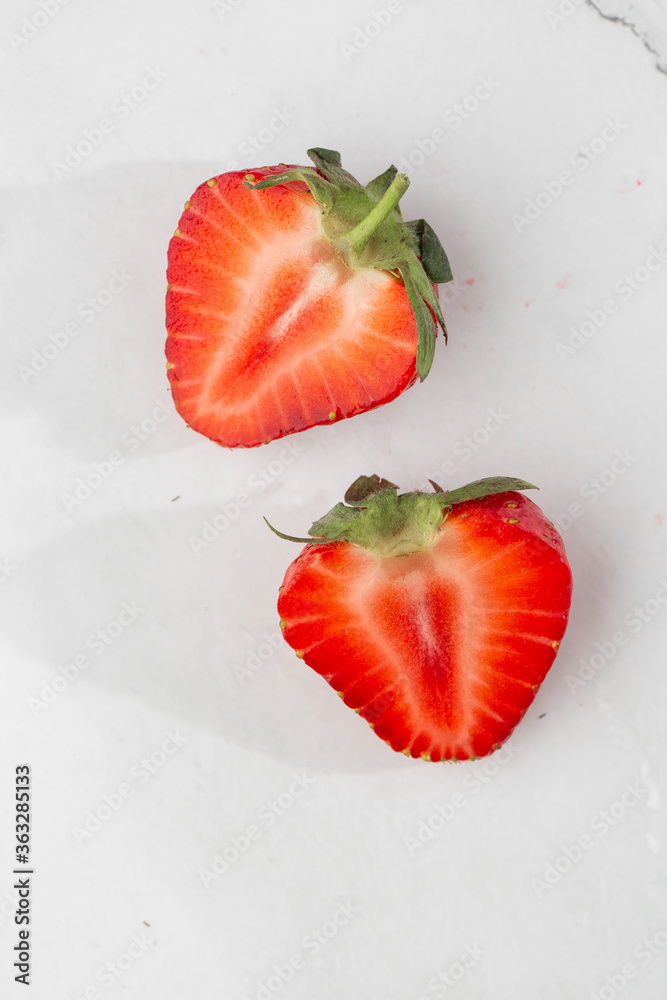 Fresh ripe perfect pieces strawberry on white marble background. Fresh strawberry isolated. Natural food backdrop with red berries. Strawberries sale in a food market in summer. Fresh ripe perfect pieces strawberry on white marble background. Fresh strawberry isolated. Natural food backdrop with red berries. Strawberries sale in a food market in summer.