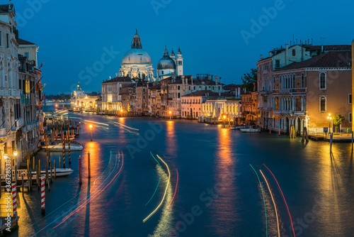 View of Basilica di Santa Maria della Salute and grand canal from Accademia Bridge at night in Venice, Italy. © kanonsky