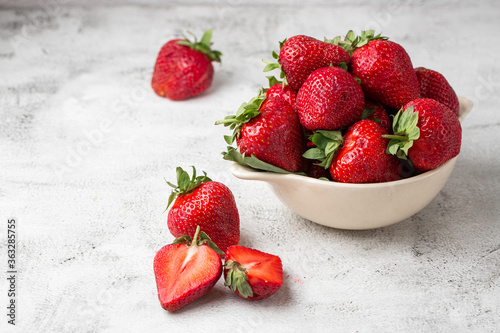 Fresh strawberries in a bowl on marble white table. Fresh nice strawberries. Strawberry field on fruit farm. Heap of Red strewberry on plate close up. Juice strawberry. Strawberry field on fruit farm.