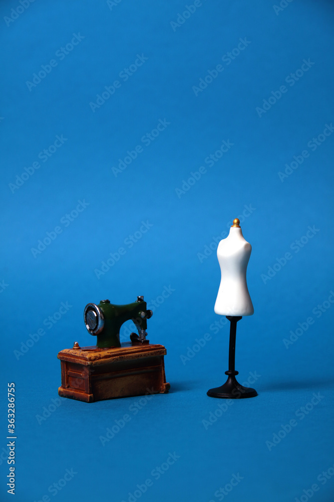 tailor's dummy and sewing machine isolated on blue background