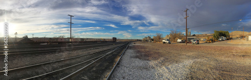Panorama view of beautiful sunset sky over railroad tracks & side road in California suburb