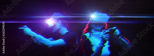 Couple with virtual reality headset are playing game. Image with glitch effect.
