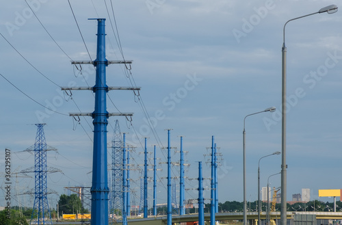 Towers of high voltage power lines against the cloudy sky. 