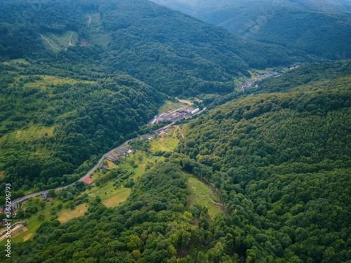 Aerial view of the beautiful wooded Carpathian mountains and small village, summer landscape, outdoor travel background, Transcarpathia (Zakarpattia), Ukraine