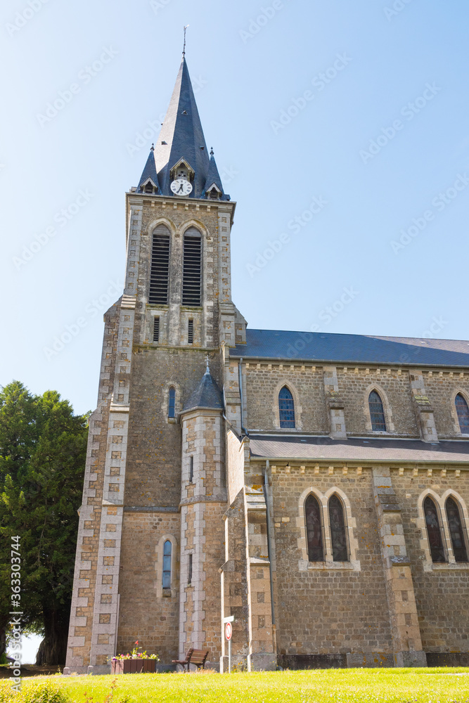 Beautiful long shot of Notre-Dame-de-l'Assomption church (La Lande Patry, Normandy, France). Sunny day in the north of France. Stone christian church.