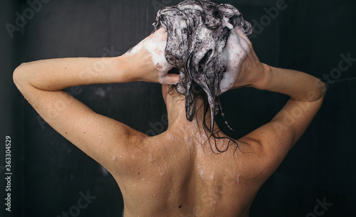 Young pretty woman take shower with shampoo