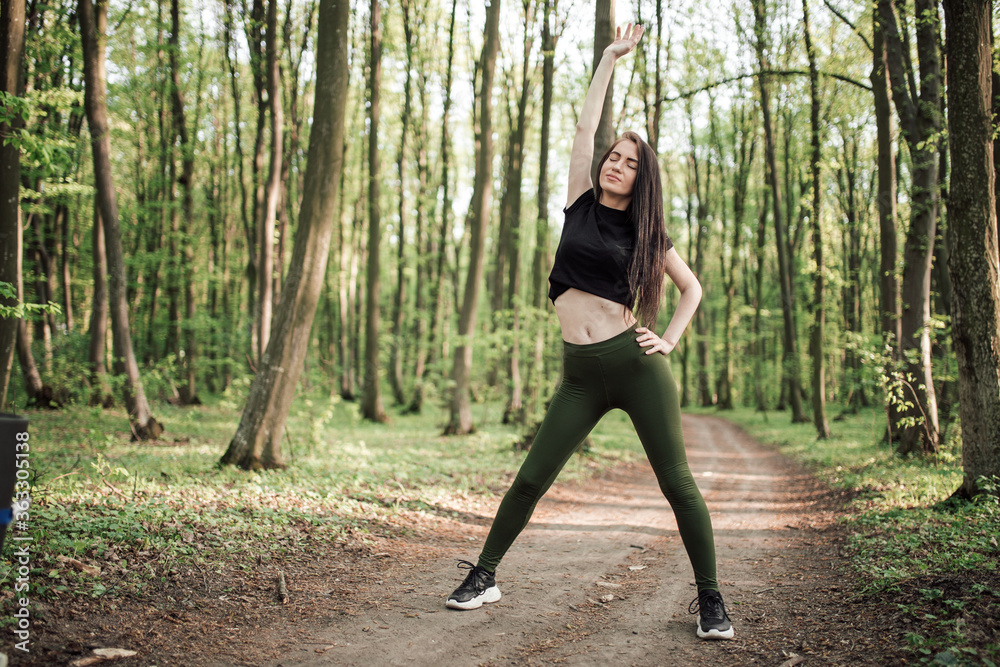 Young sporty woman running in forest