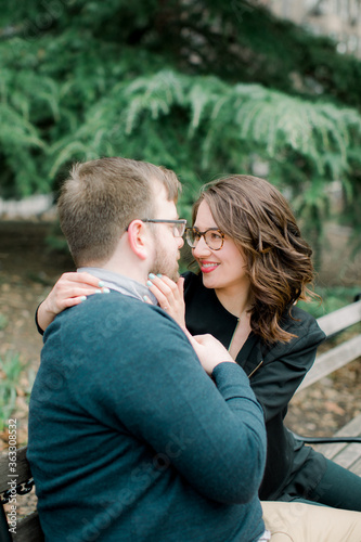 A couple in love having a romantic moment and showing mutual affection in a local urban park outdoors