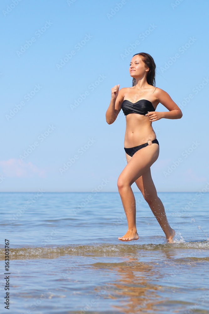 Fototapeta premium Woman in bikini run on beach