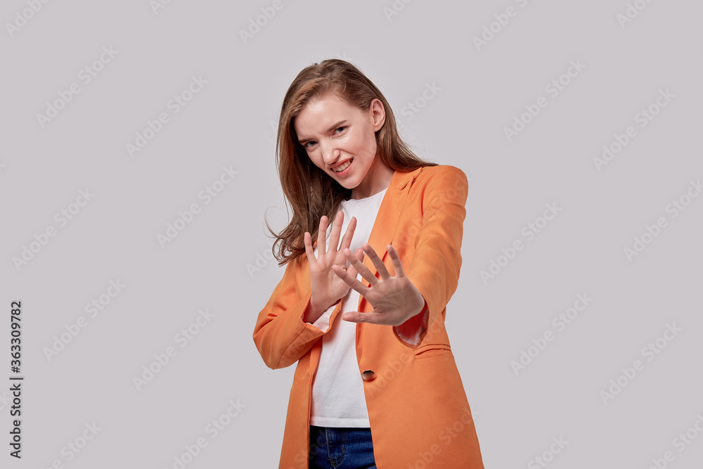 Frightened girl put her hands forward, defending herself with her hands. Frightened girl put her hands forward, defending herself with her hands.