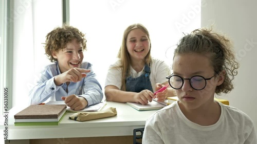 Two teens scoff at their defenseless classmate. Child cruelty. School bullying.