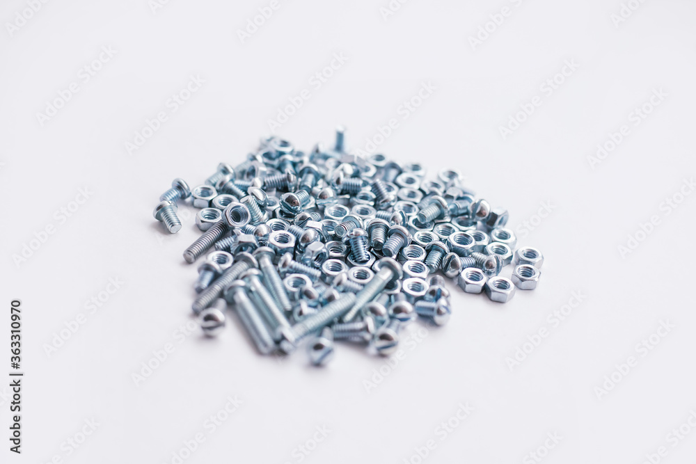 Chrome-plated screw nuts and bolts top view. Bolts and nuts on a white background. Construction industry. Chrome-plated screw nuts and bolts top view. Bolts and nuts on a white background. Construction industry.