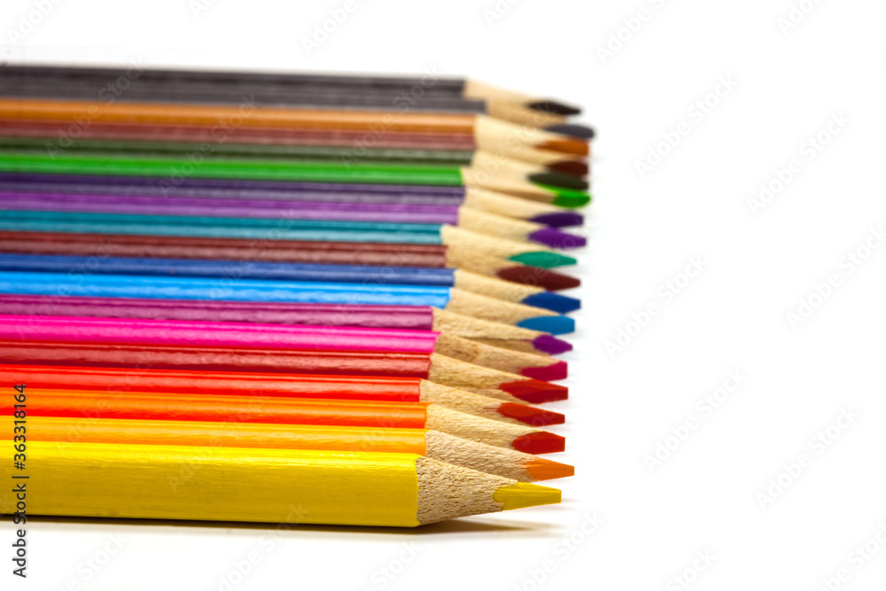 Fototapeta premium colored pencil set loosely arranged on white background, selective focus