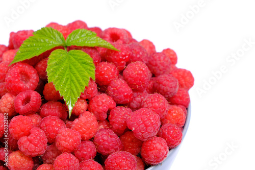 Raspberry berry in the Cup is decorated with a green leaf on a white background.