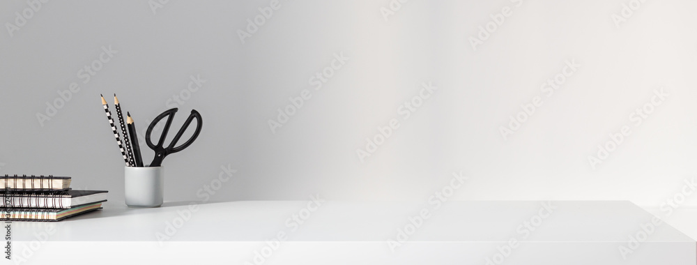 Home office desk and supplies on grey wall background. Stylish and