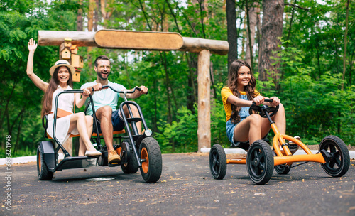 Modern happy young tourist family on vacation riding on bikes and have fun together.