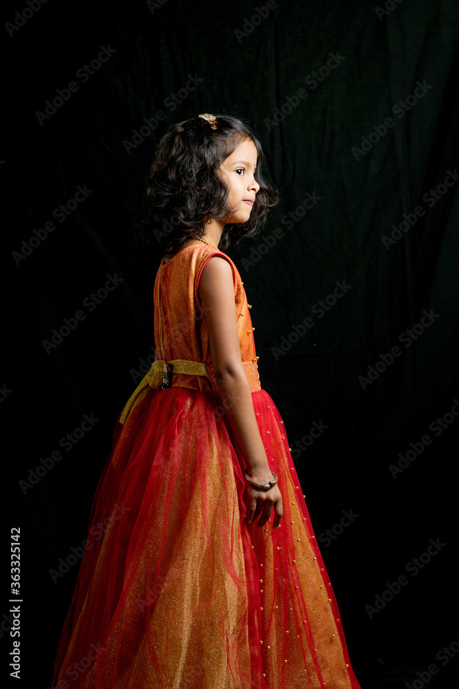 Happy little girl child wearing princess gown and dancing