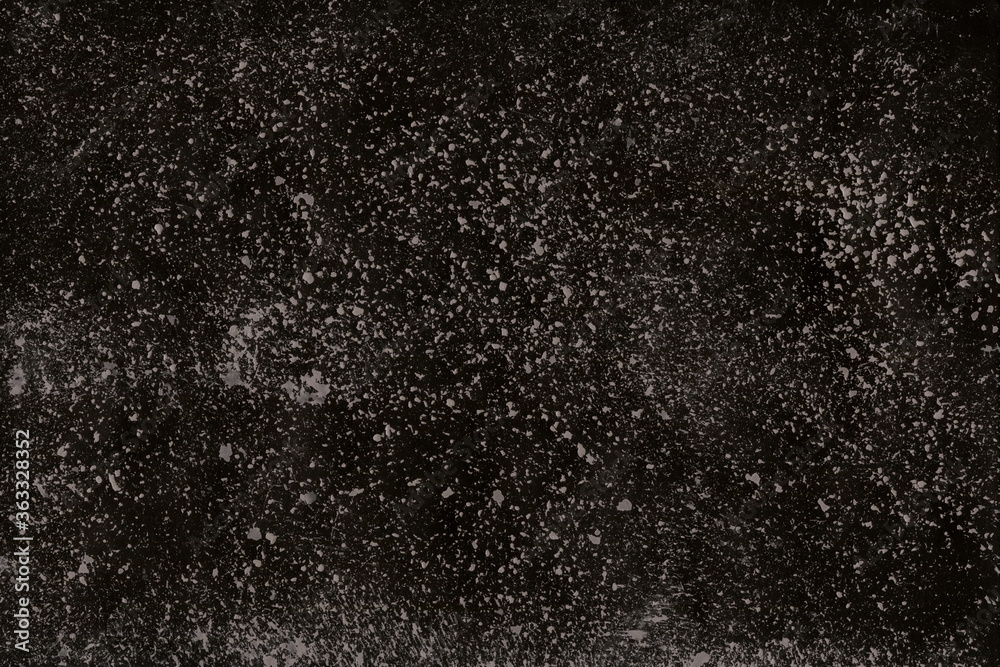 Grunge surface texture with splashes, dots, grit and noise. A texture with random gray dots on a black background, similar to the starry sky, space.