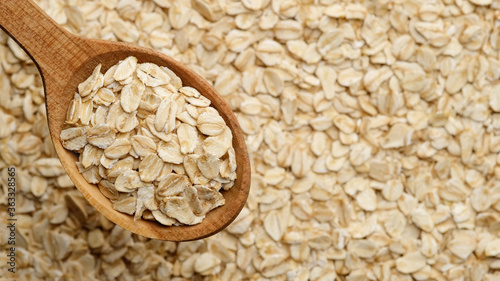 oatmeal in wooden spoon and on background. flakes    ereals