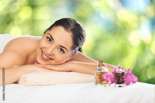 Beautiful young woman relaxing with a massage in the spa salon