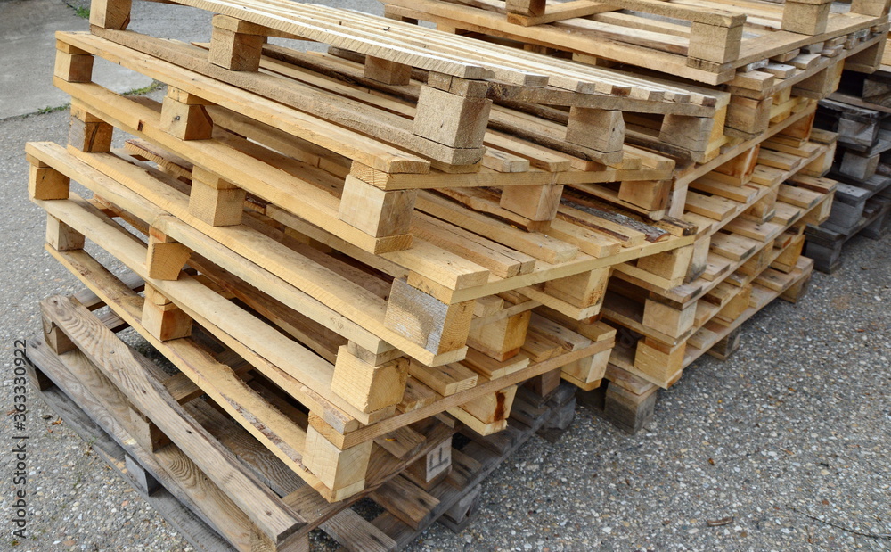 stacked wooden pallets. Wooden production pallets stand piled in a pile. Close-up. stacked wooden pallets. Wooden production pallets stand piled in a pile. Close-up.