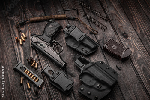 the gun and holster lay on a wooden Board photo