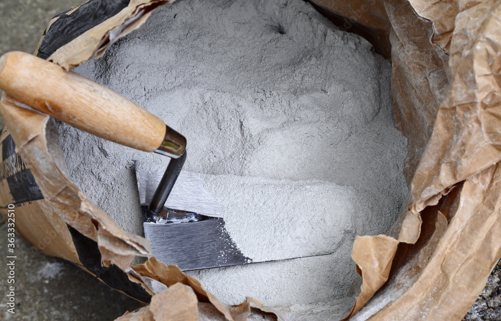 Close up trowel and cement powder in paper bag. Close up trowel and cement powder in paper bag.