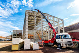 The crane (HIAB) extend its lift bucket to roof of the new building for isolation in the construction site. It is a Swedish manufacturer of loader cranes, demountable container handlers.