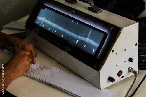 The radiography film operator level 2 evaluation  radiographs of the welds with viewer and he is writing some reports. photo