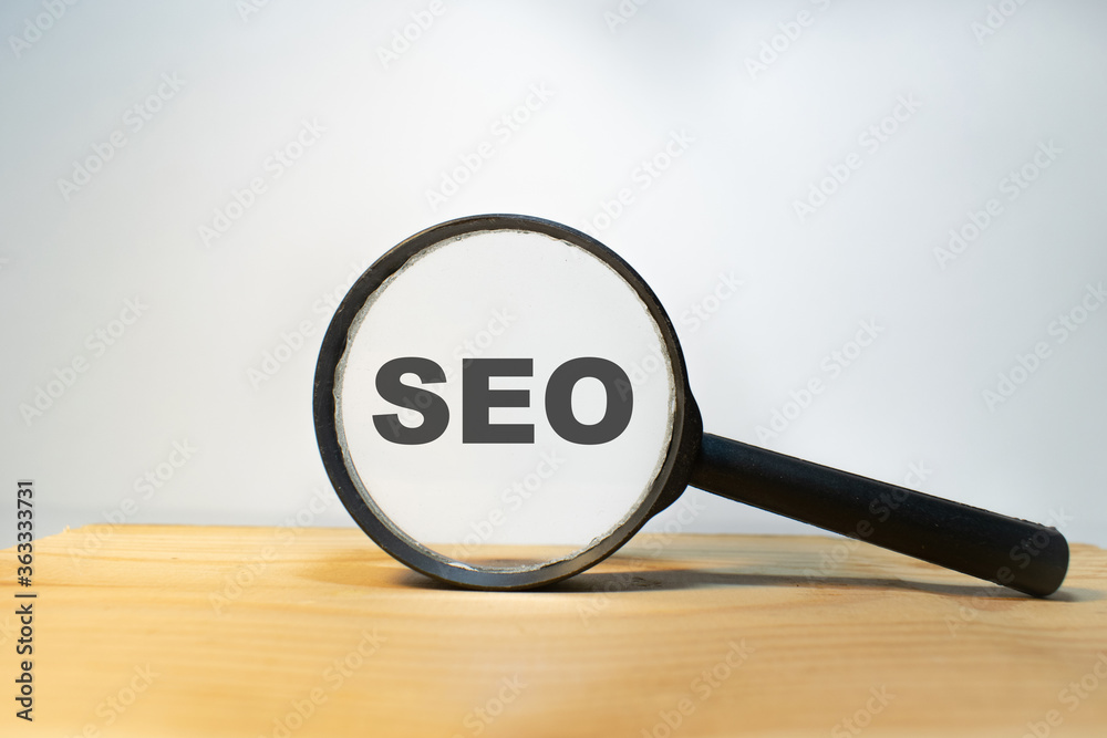 Focused on SEO concept. Magnifier glass with text KPI on wooden table in sunlight. Business concept Focused on SEO concept. Magnifier glass with text KPI on wooden table in sunlight. Business concept