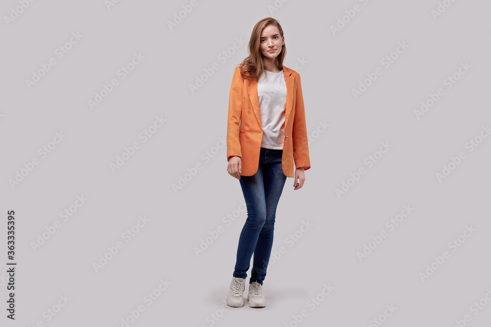 Full length cute girl in fashionable casual wear, a bright orange jacket Full length cute girl in fashionable casual wear, a bright orange jacket