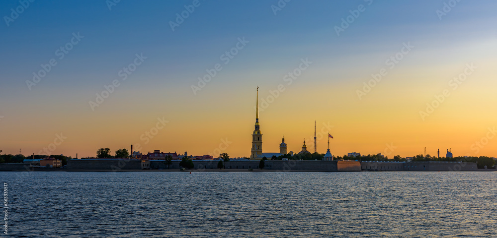 Sunrise panorama of Petropavlovskaya (Peter and Paul) fortress and orthodox Peter and Paul Cathedral on Zayachy Island after summer white night. Saint-Petersburg, Russia