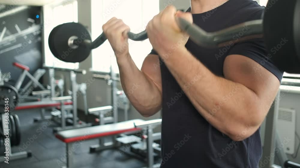 Portrait of a pumped athlete's hands shaking his biceps in the gym Portrait of a pumped athlete's hands shaking his biceps in the gym