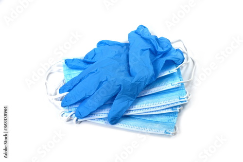 A pair of thin blue medical latex gloves and face shield on a white background. Disposable rubber medical gloves and mask. Protective subjects. Remedies.