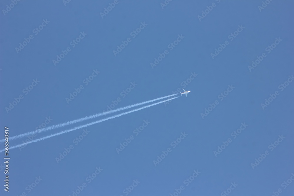 The plane and the track of the plane in the blue sky. The concept of moving forward. The plane and the track of the plane in the blue sky. The concept of moving forward.