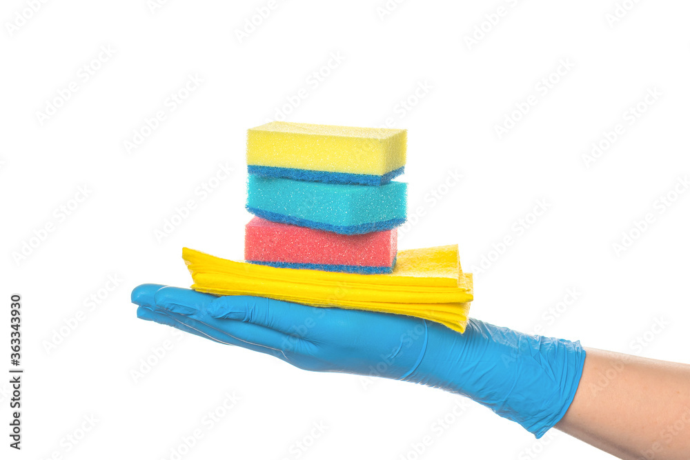 a hand in a blue glove holds multi-colored sponges and a yellow rag for cleaning rooms. on a white background. a hand in a blue glove holds multi-colored sponges and a yellow rag for cleaning rooms. on a white background.